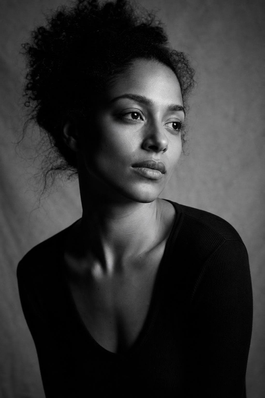 AI headshot in editorial black-and-white style — strong side lighting, film grain